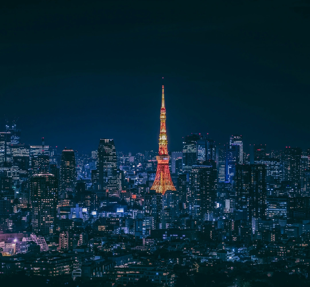 Tokyo Tower illuminated above the city skyline at night, photographed by Steven Lynn